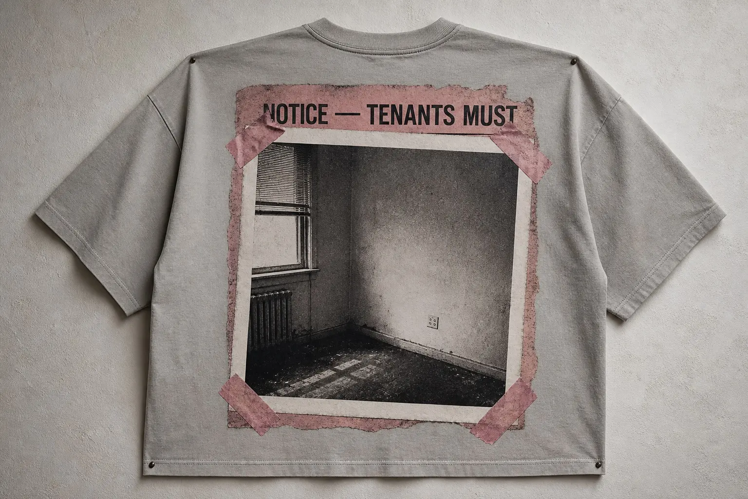 A plaster grey oversized tee pinned flat to a wall, printed across the back with a small snapshot taped by its four corners over a larger torn notice, the notice's exposed top edge reading NOTICE — TENANTS MUST, and the photograph itself showing an empty room corner with a curtained window, a radiator and a wall socket